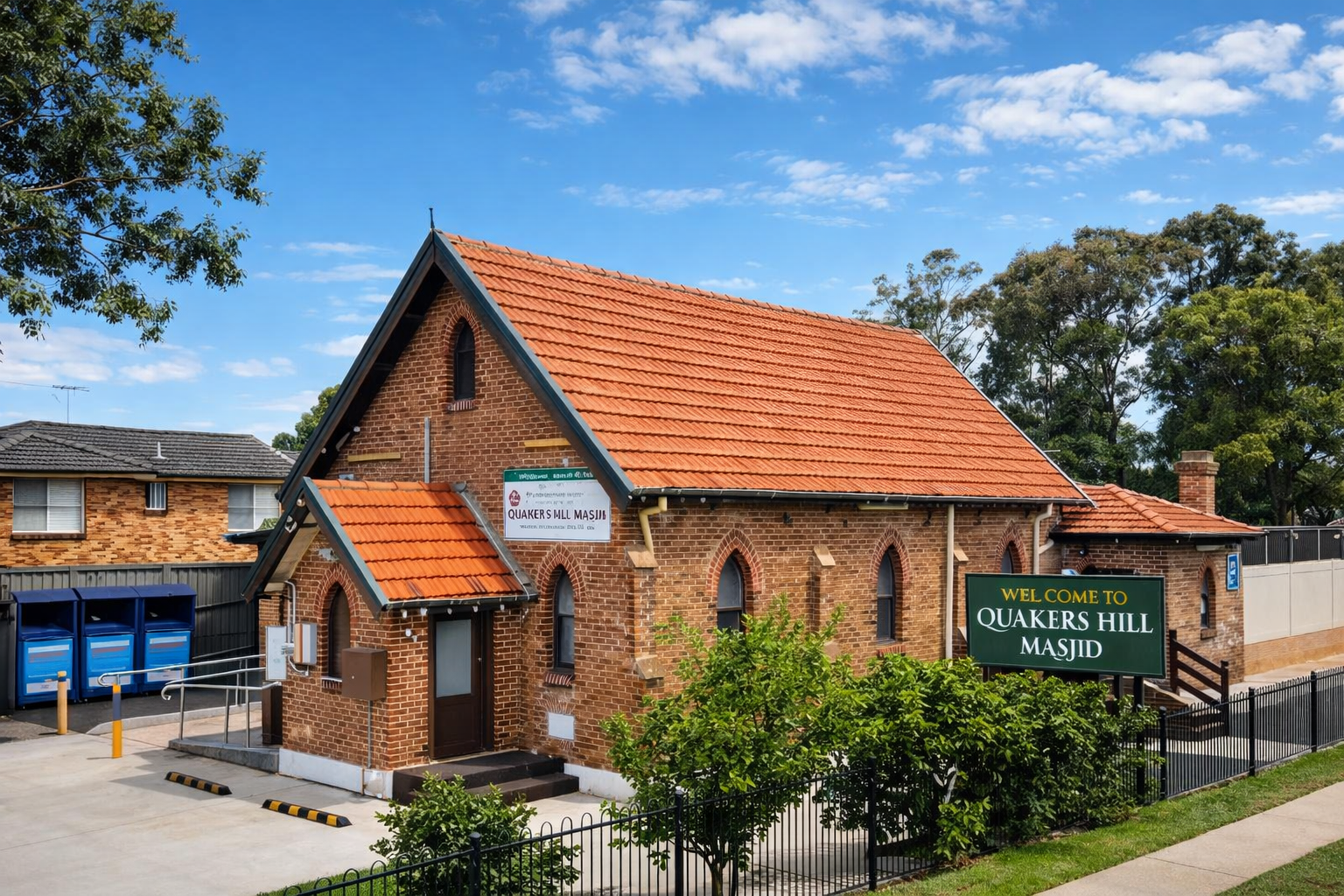 Quakers Hill Masjid brick building with welcome sign on a clear day